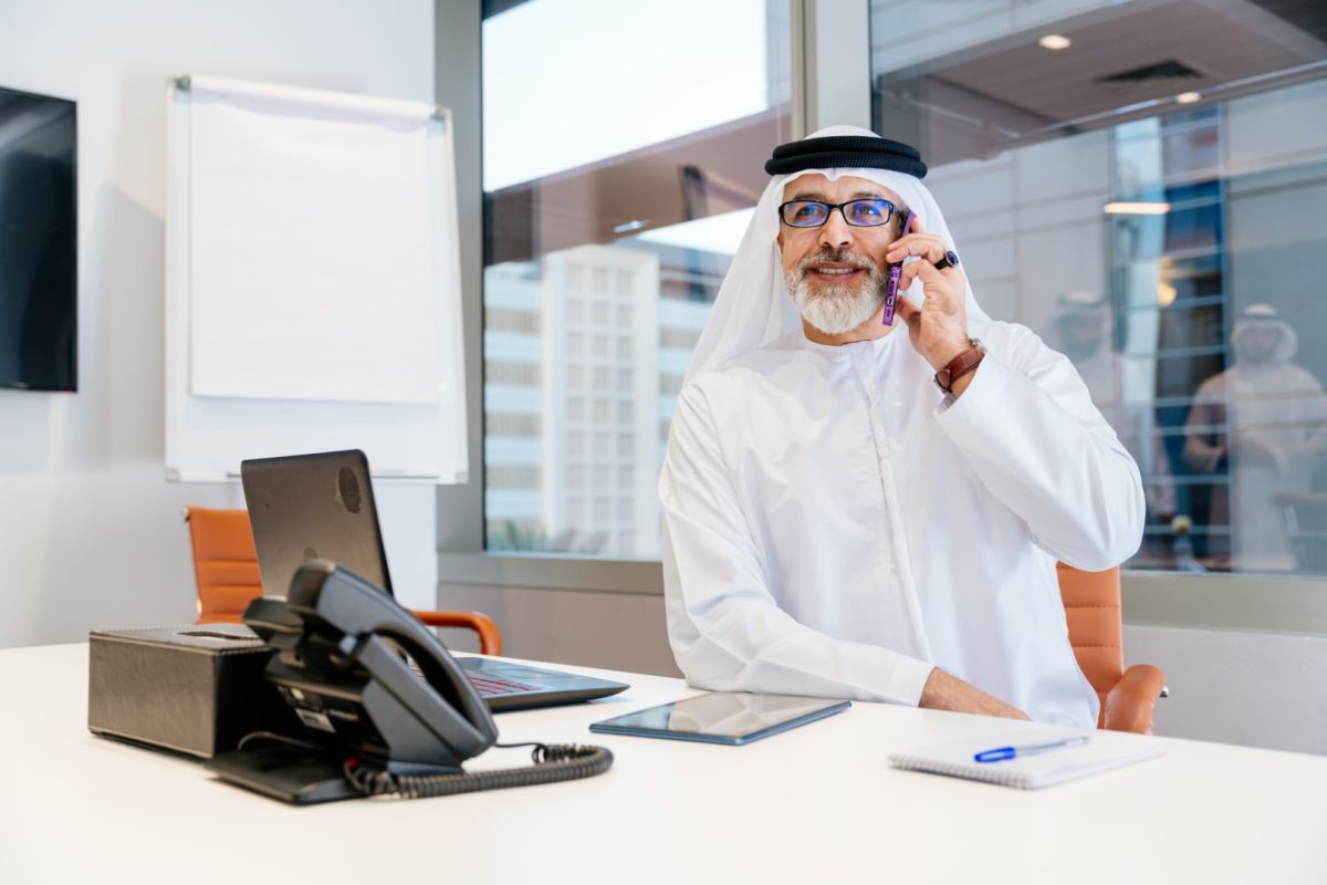 Portrait of mature middle-eastern corporate businessman wearing kadora and working in the office in Dubai